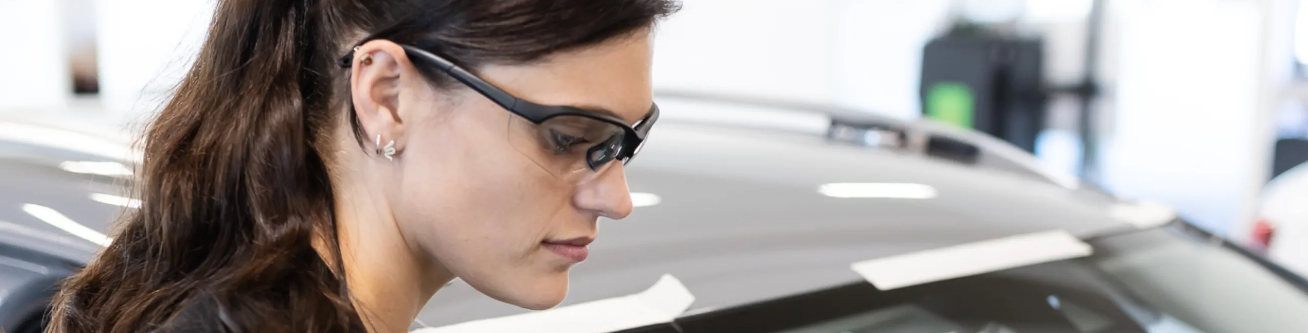 kvindelig tekniker reparerer bilglas